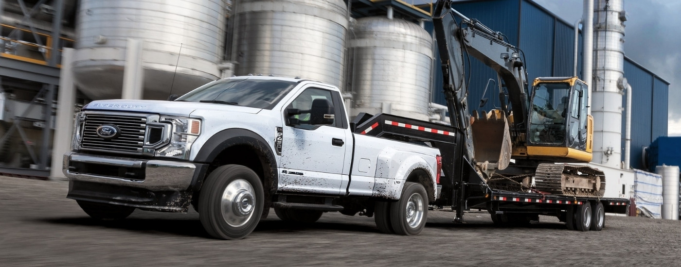 White 2022 Ford F-450 towing construction equipment